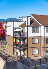 Corner of three storey apartment building on sunny day