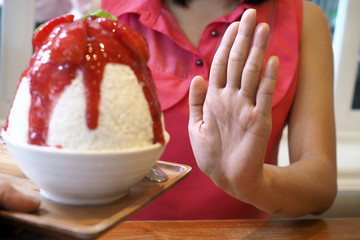 Women push Bingsu cup. Refused to eat all kinds of sweets. Avoid sugar and sweets for good health. diet concept