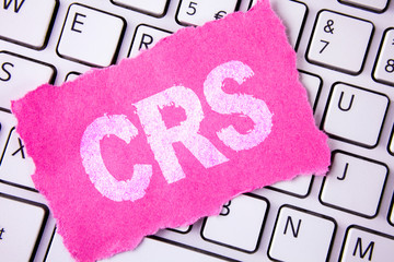 Conceptual hand writing showing Crs. Business photo showcasing Common reporting standard for sharing tax financial information written Tear Sticky note paper placed White Keyboard.