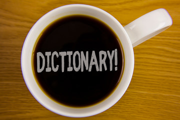 Word writing text Dictionary Motivational Call. Business concept for Learning another vocabs and synonyms from book written Black Tea in White Cup placed wooden table. Top view.