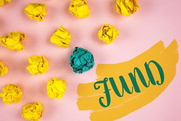 Handwriting text writing Fund. Concept meaning Large amount of money is released from bank for particular purpose written Painted background Crumpled Paper Balls next to it.