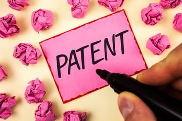 Text sign showing Patent. Conceptual photo License that gives rights for using selling making a product written by Man Sticky Note paper holding Marker plain background Paper Balls.