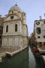 Fototapeta na wymiar A church, canal and a gondola in Venice