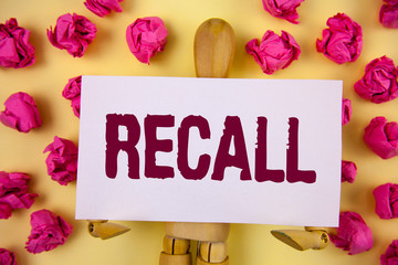 Text sign showing Recall. Conceptual photo Bring back to memory Ordering the return of a person or product written Sticky Note paper plain background Paper Balls and Wooden Robot Toy.