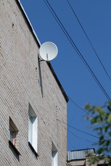 Satellite TV on the wall of a multistory building.