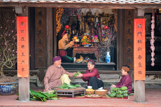 Vietnamese Family Members Making Banh Chung Together On Old-styled House Yard. Chung Cake Is A Very Well-known Dish That Could Never Miss On The Altar, And Family Meal Of Vietnamese During Tet Holiday