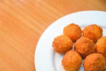 Cheese balls, Breaded mozzarella cheese balls with tomato in white dish on wood blackground