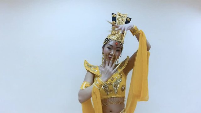 Beautiful asian woman dancing with hands with long nail manicure in a traditional thai yellow dress