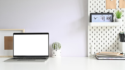 Workspace computer, Empty screen laptop and office supplies on white office desk.