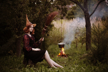 young witch by  fire in night forest