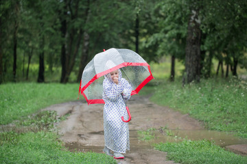funny little girl with umbrella in rain