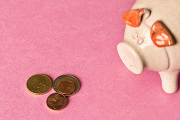 Piggy Bank and a few coins on the orange background. Close up. The concept of saving money. Selective focus.