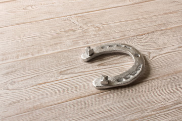 Silver horseshoe on a wooden table. An old horseshoe.