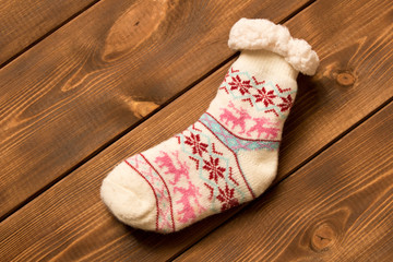 Funny Christmas sock on wooden background. The concept of Christmas