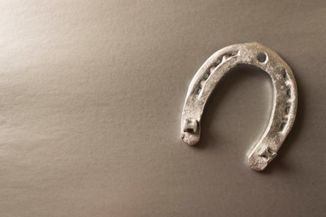Silver horseshoe on a gray background. An old horseshoe. Close up.