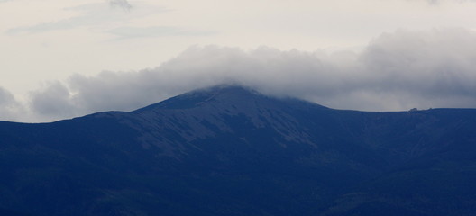 Fototapeta na wymiar Sniezka Mountain in the clouds seen from Krzyzna Gora in Rudawy Janowickie