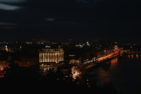 KYIV, UKRAINE - MAY 21, 2019: Beautiful view of night cityscape with illuminated buildings near river