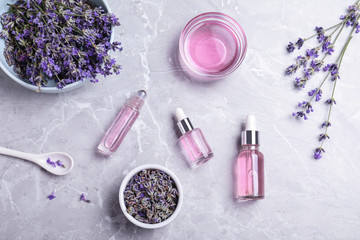 Flat lay composition with lavender essential oil on marble background