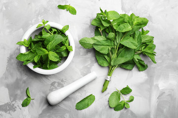 Fresh mint with mortar and pestle on grey marble table, flat lay - obrazy, fototapety, plakaty