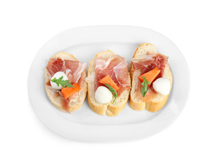 Sandwiches with fresh melon, prosciutto and mozzarella on white background, top view