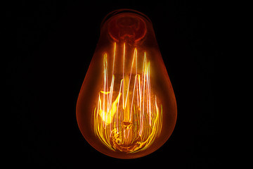 Light bulb with beautiful filament on a dark background