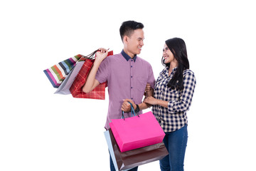 Asian couple carrying shopping bags on white background