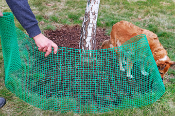 A man holds a plastic net that is useful in gardening.