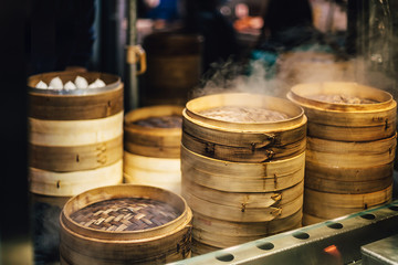 Piles of stacking bamboo steamers are steaming for dim sum. Street food of Jiantan in Taipei, Taiwan. Focus on front bamboo steamers.