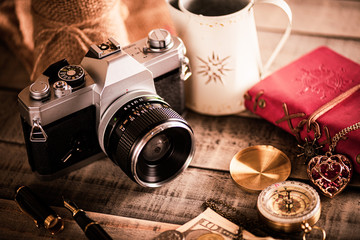 vintage items, pen red book, coins money, compass and retro photo film camera on wood background.