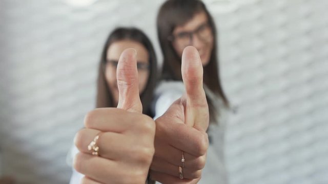 Two Female doctors with thumbs up gesture against white background