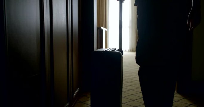 adult traveler woman enters the hotel room, puts the bag, looks in the mirror removing the straw hat