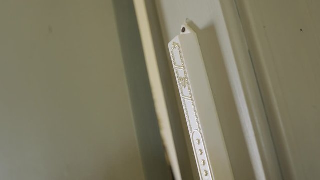 Touching a Jewish door protector called Mezuzah - Close Up
