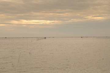 Soft ocean waves and bubbles on the beach with a sunset sky background