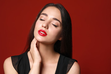 Beautiful young woman with bright lipstick on color background