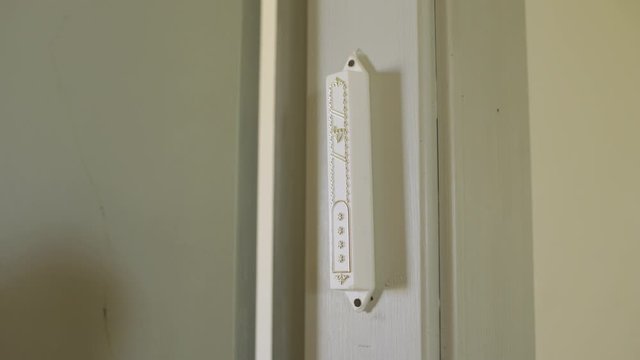Hand on a Mezuzah - Jewish tradition when entering or exiting room
