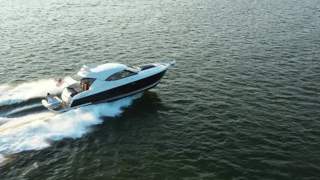 Long profile tracking shot of speed boat and wake; pull away; rising, ascending; smooth footage; 4k