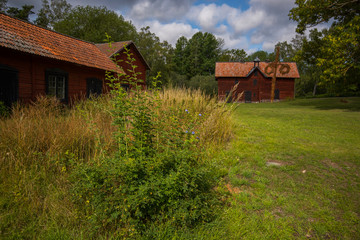 Old Swedish rural Falu red houses at the island Lov&ouml; in Stockholm a summer day