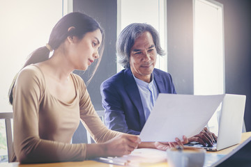 Crop image of young attractive businesswoman working with paperwork has been guided and consulting by senior colleague