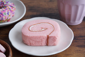 Obraz na płótnie Canvas ピンクのストロベリーロールケーキとおやつタイム