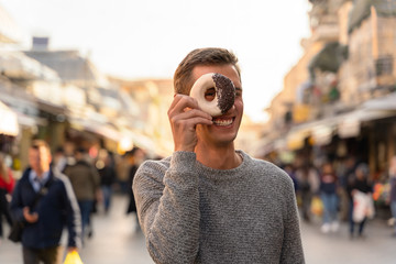 young man eating a donut in an alley