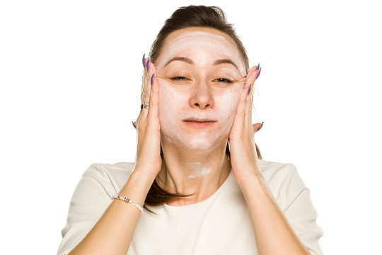 Funny Woman Applying Face Cream On White Background