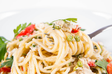 Spaghetti with cream sauce with smoked mackerel, peas ,bell pepper and some parsley eaten with a fork