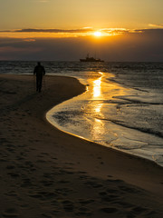 Fototapeta na wymiar beautiful sunset view of the sea, the silhouette of a tall ship, beautiful and dramatic colors