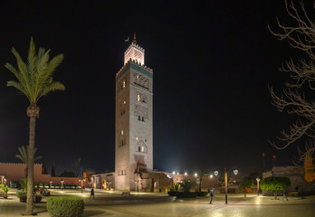 Fototapeta premium Koutoubia Mosque in city center with narrow street and traditional houses and people, muslim architecture,.