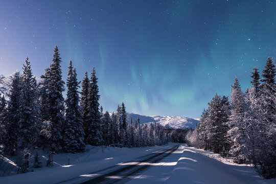 A road leading towards snow covered Pallas fell at winter night in Pallas-Yllästunturi national park in Muonio Finland © Jamo Images