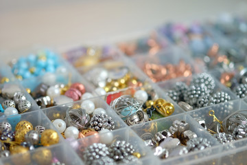 Vintage metal golden and plastic bead in box accessories background. Selective focus image