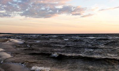 dramatic sunset, seashore, strong winds and blurred waves, beautiful and colorful skies, dusk