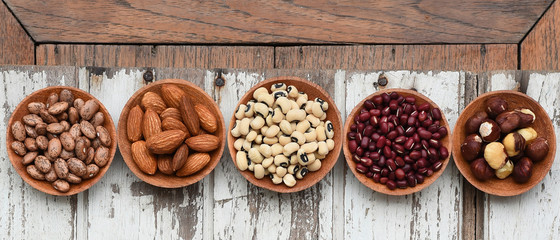 Different beans in bowl on wooden background