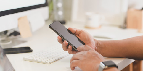 Fototapeta premium Close-up view of man holding smartphone