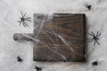 Wooden cutting Board in the background of the web spiders. Concept Halloween.